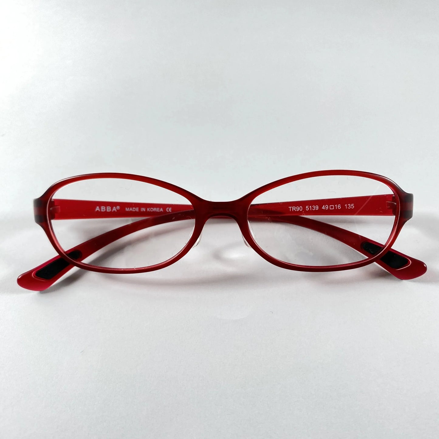 Red oval eyeglasses with sporty frame design on white background