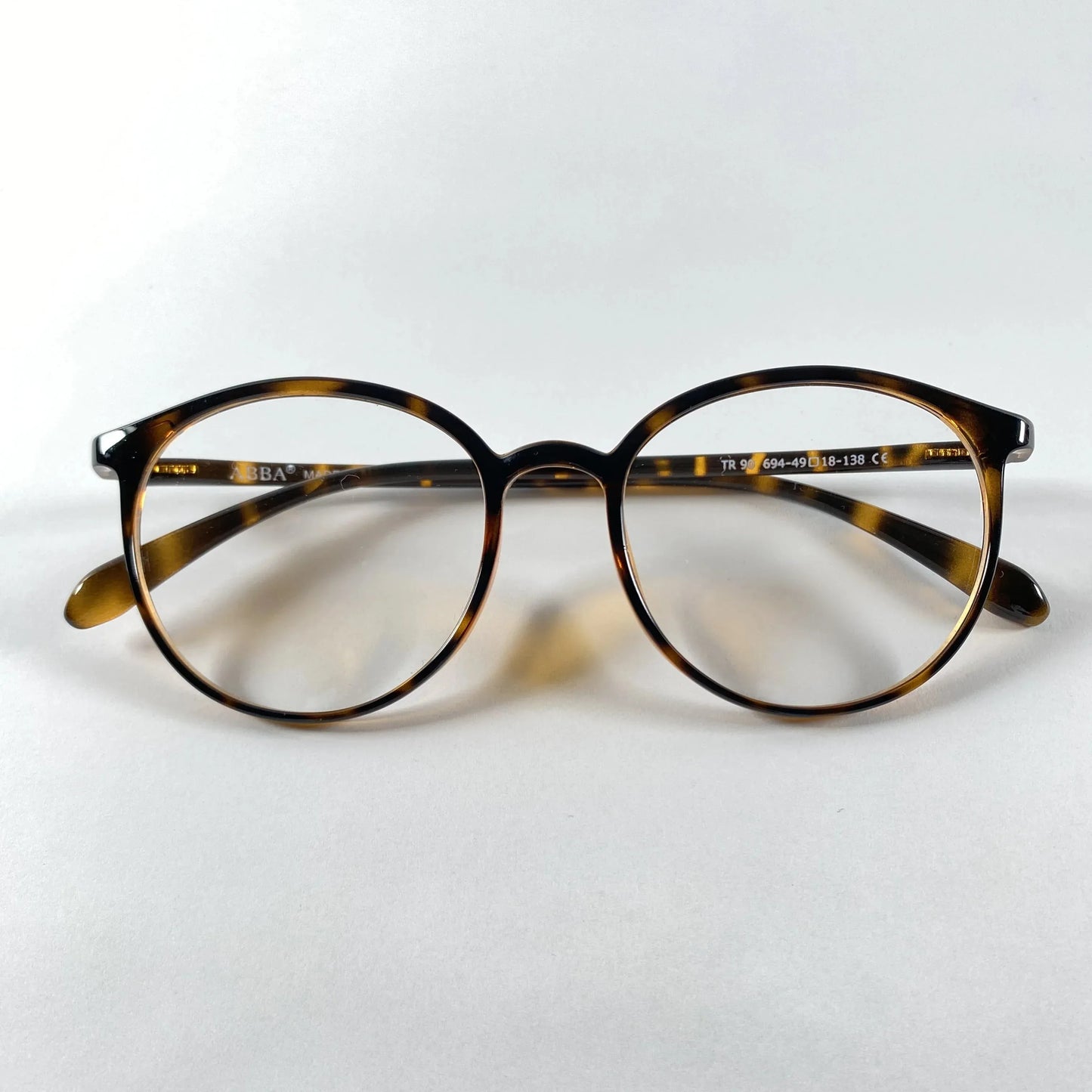 Round tortoiseshell eyeglasses with Havana brown pattern on white background