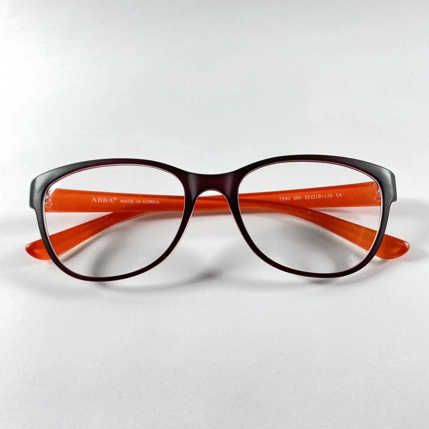 Brown and orange eyeglasses frame with clear lenses on white background