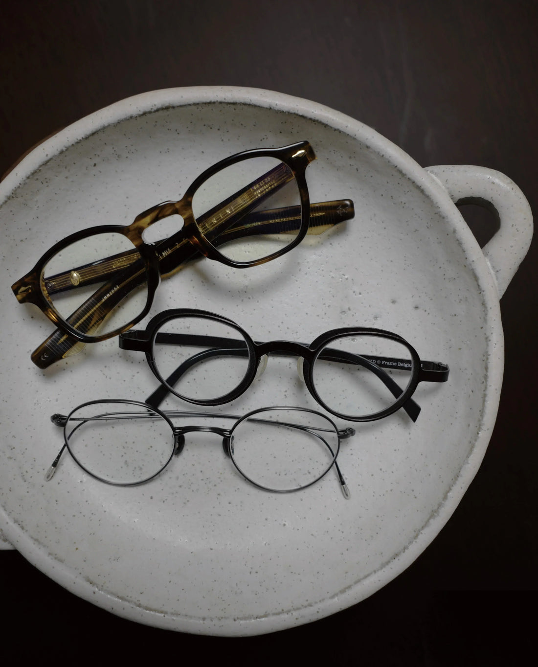 Korean-made prescription glasses displayed on a ceramic dish  — the signature aesthetic of Korean eyewear styles.