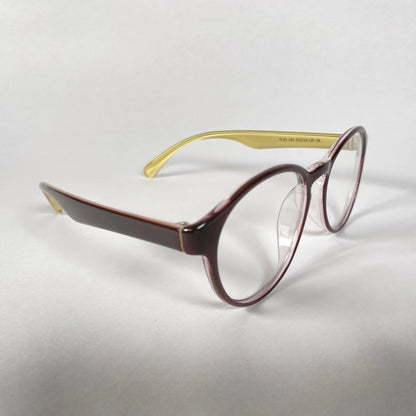 Brown glossy round eyeglasses with yellow inner arms on a white background