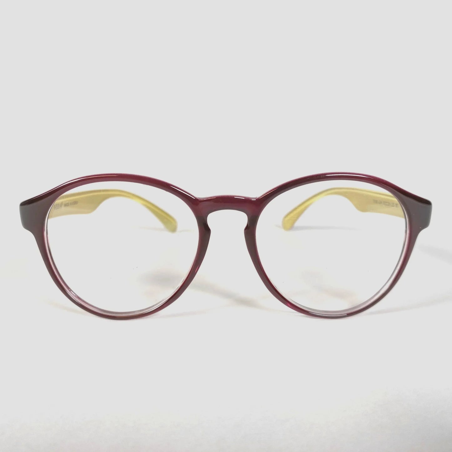 Brown glossy round eyeglasses with yellow temples on white background