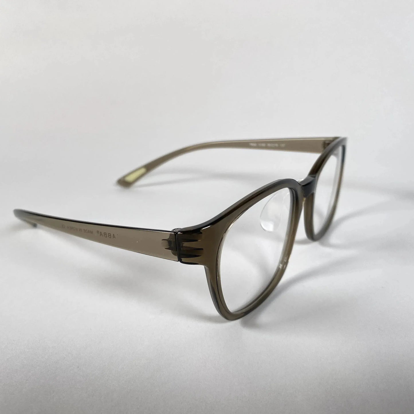 Olive green translucent eyeglasses with clear lenses on a white background