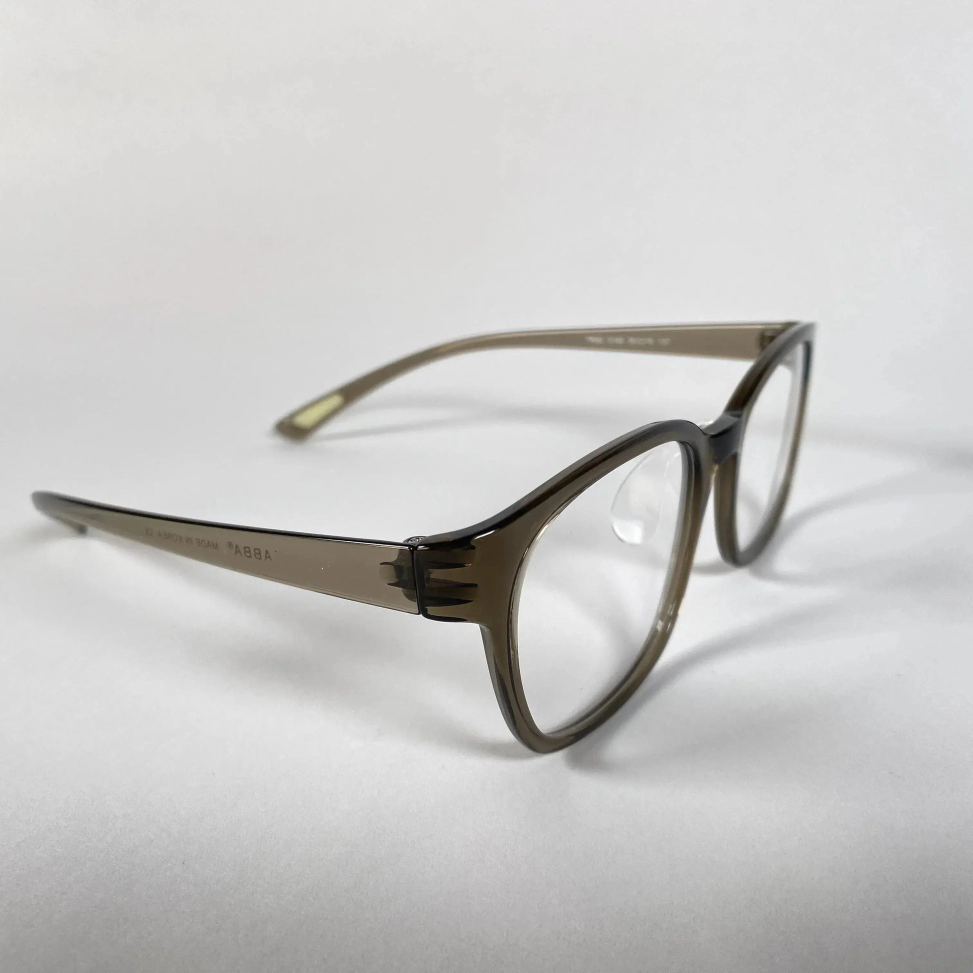 Olive green translucent eyeglasses with clear lenses on a white background