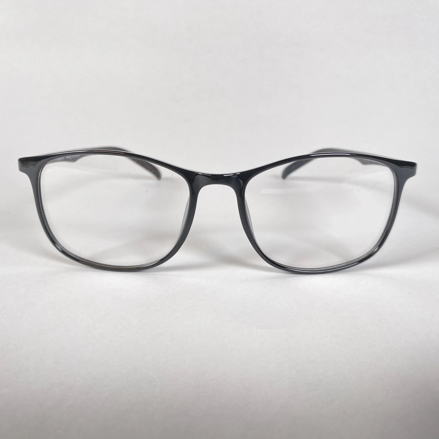 Black square eyeglasses with clear lenses on white background, stylish optical eyewear