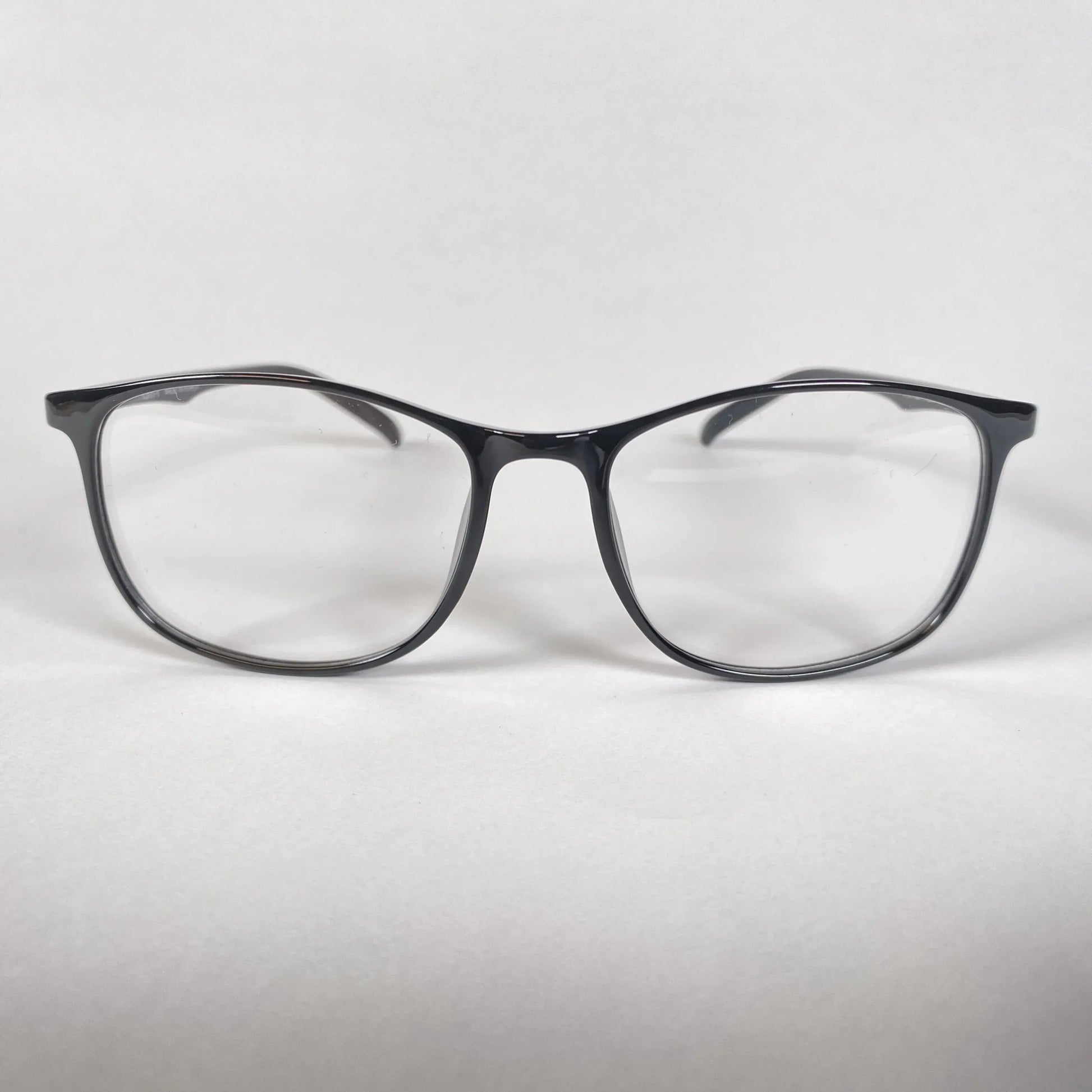 Black square eyeglasses with clear lenses on white background, stylish optical eyewear