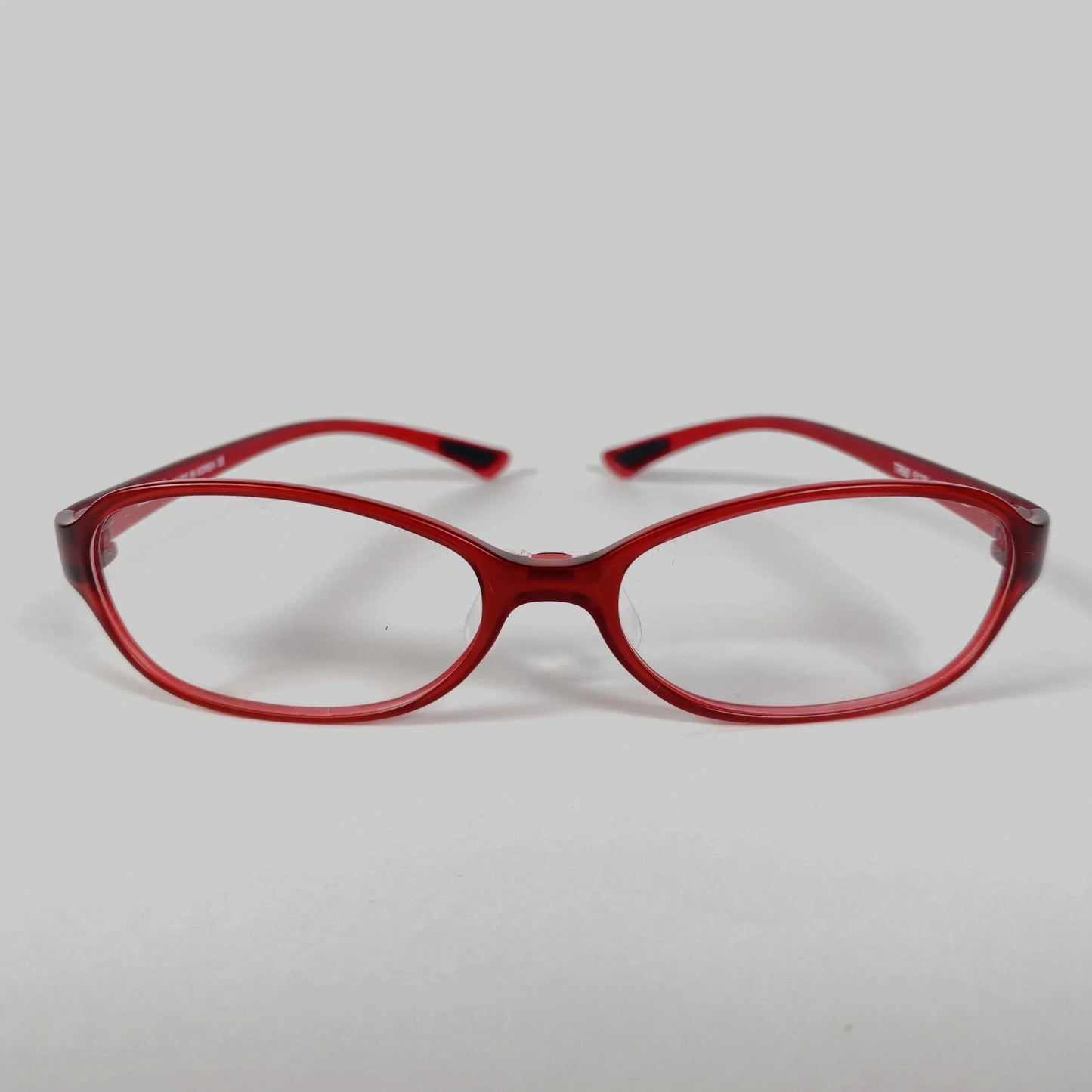 Red sporty eyeglasses with clear lenses on plain white background