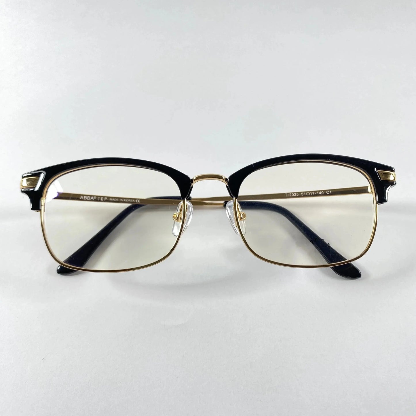 ClubVion 2035 detail view - premium gold metal bridge and lower rim contrasting with bold black upper frame