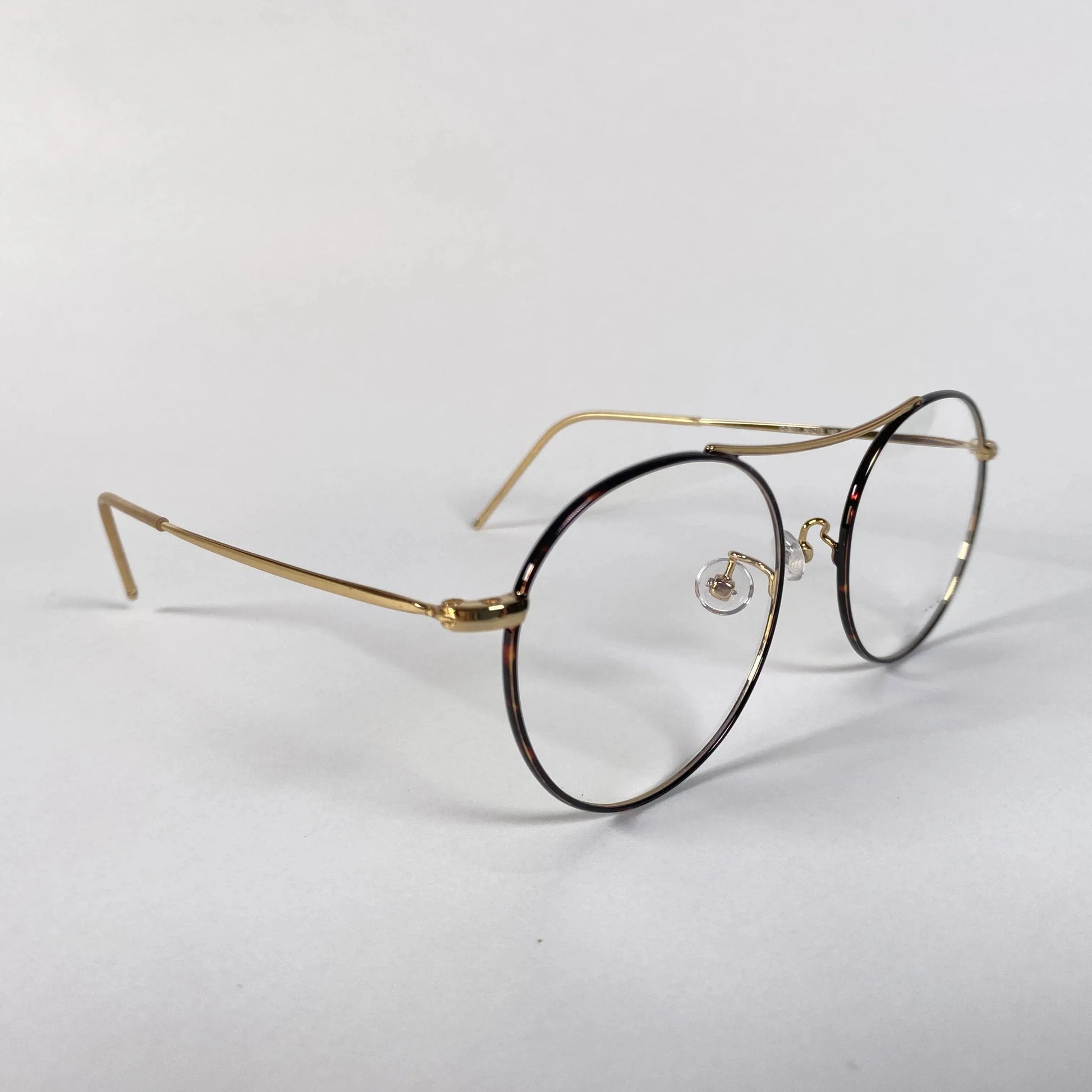 Gold round eyeglasses with thin metal frames on white background