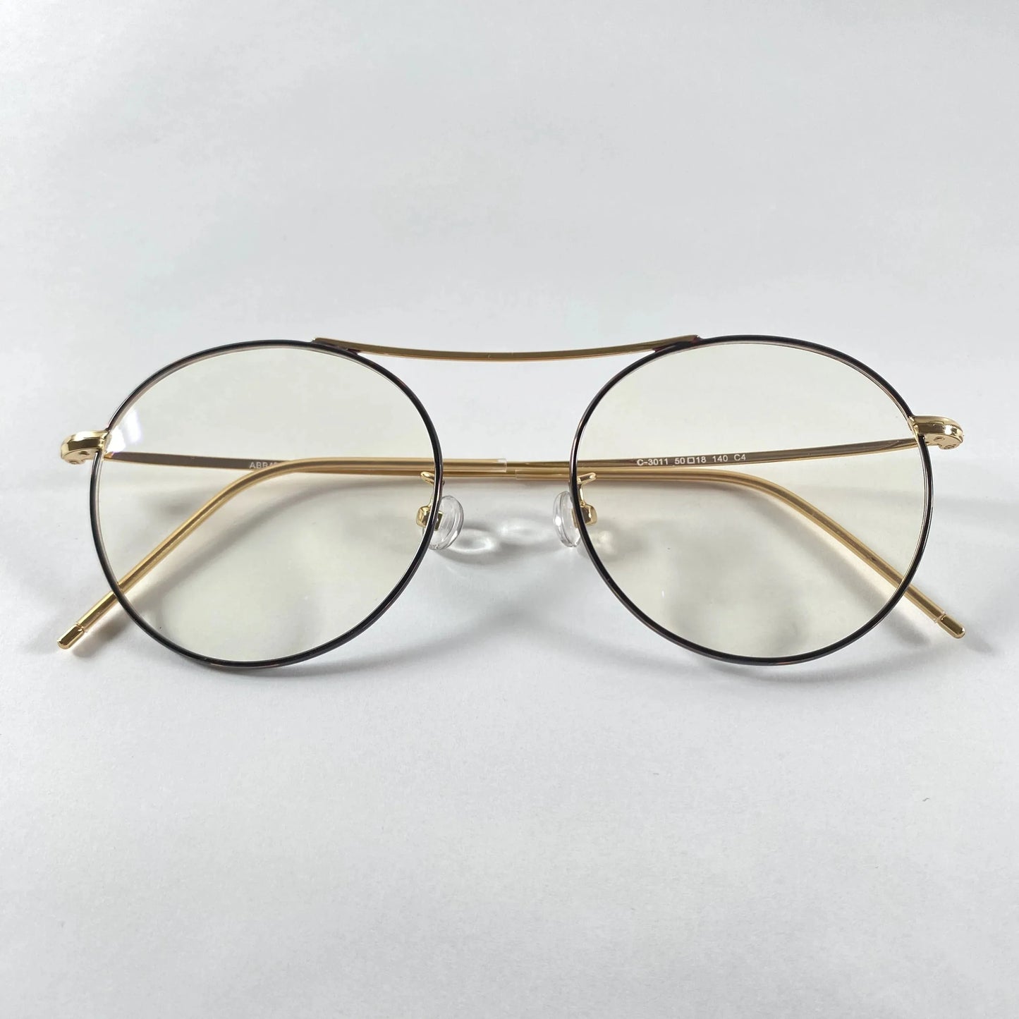 Gold round eyeglasses with metal frames and clear lenses on white background