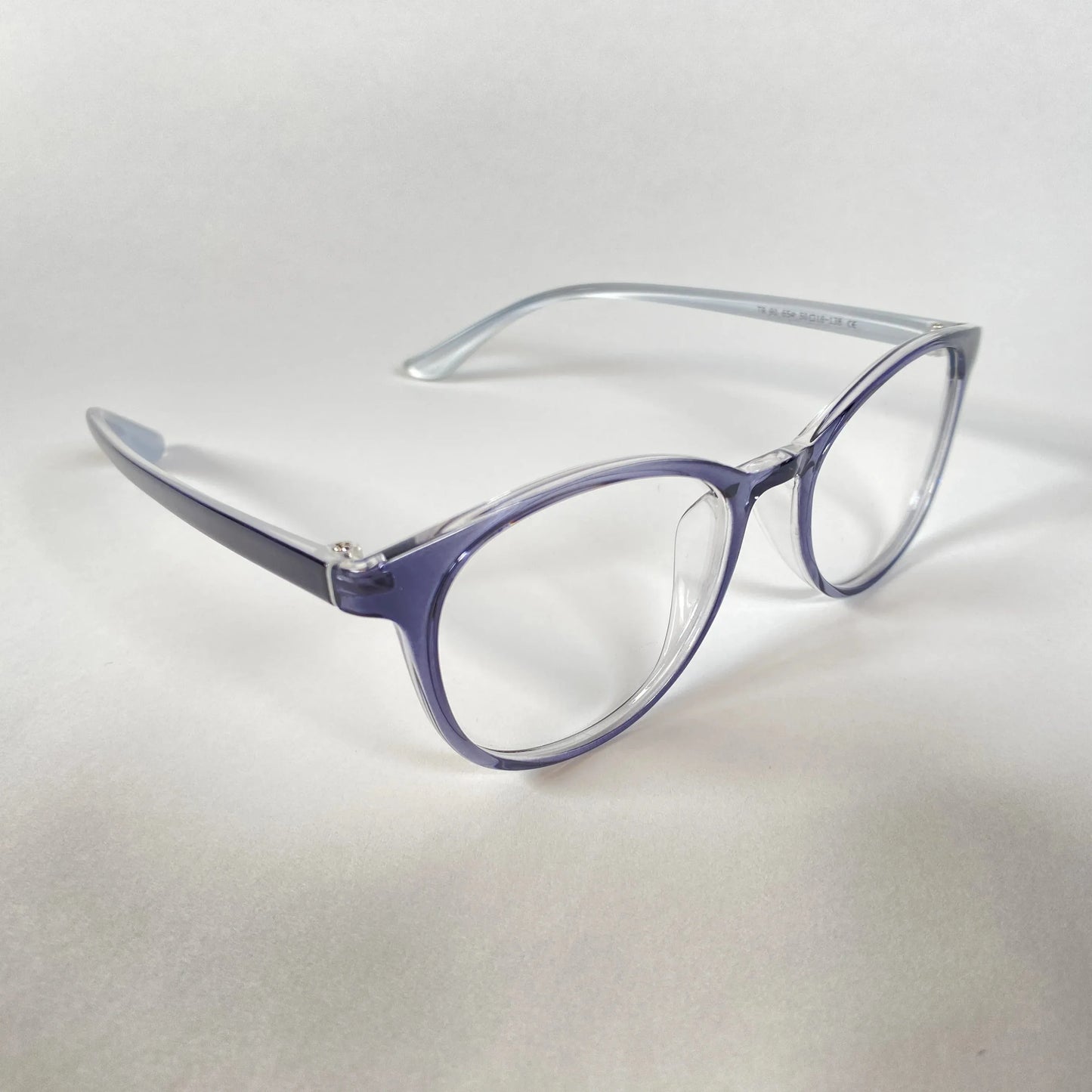 Transparent navy round eyeglasses with clear lenses on white background, side angle view