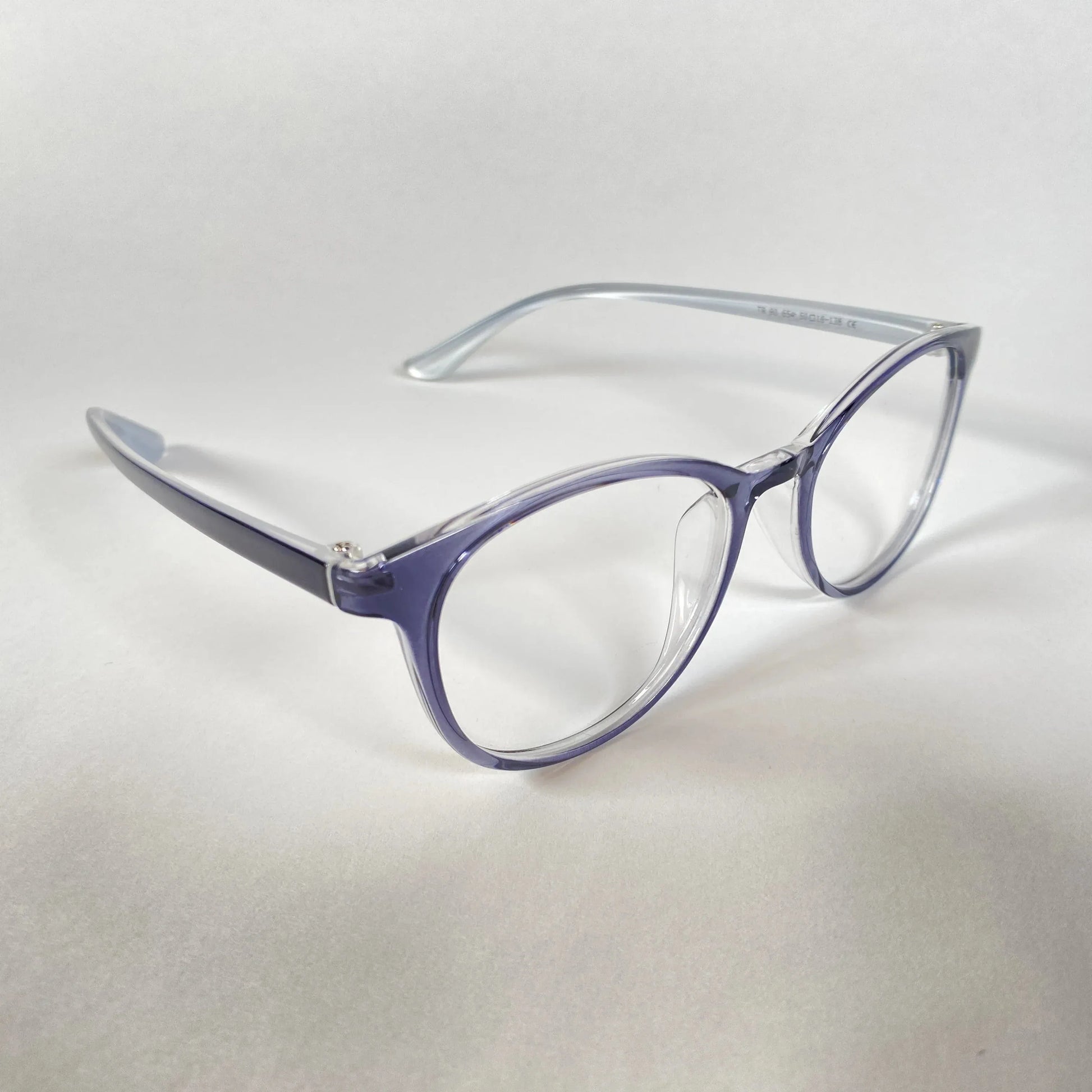 Transparent navy round eyeglasses with clear lenses on white background, side angle view
