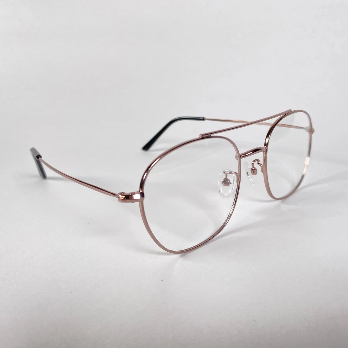Rose gold aviator eyeglasses with clear lenses on white background