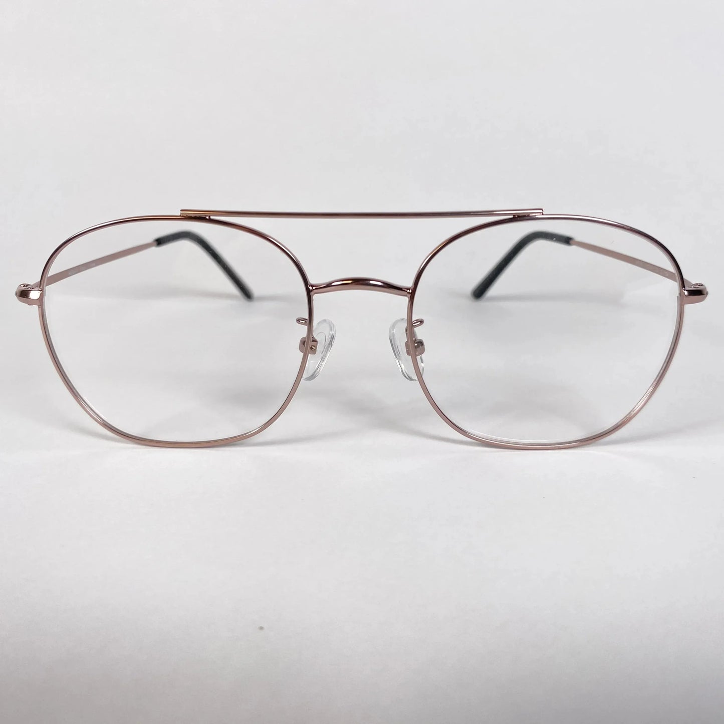 Rose gold pilot eyeglasses with thin metal frame on white background