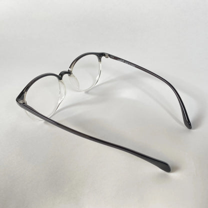 Black clear round eyeglasses with acetate frame on white background, side angle view