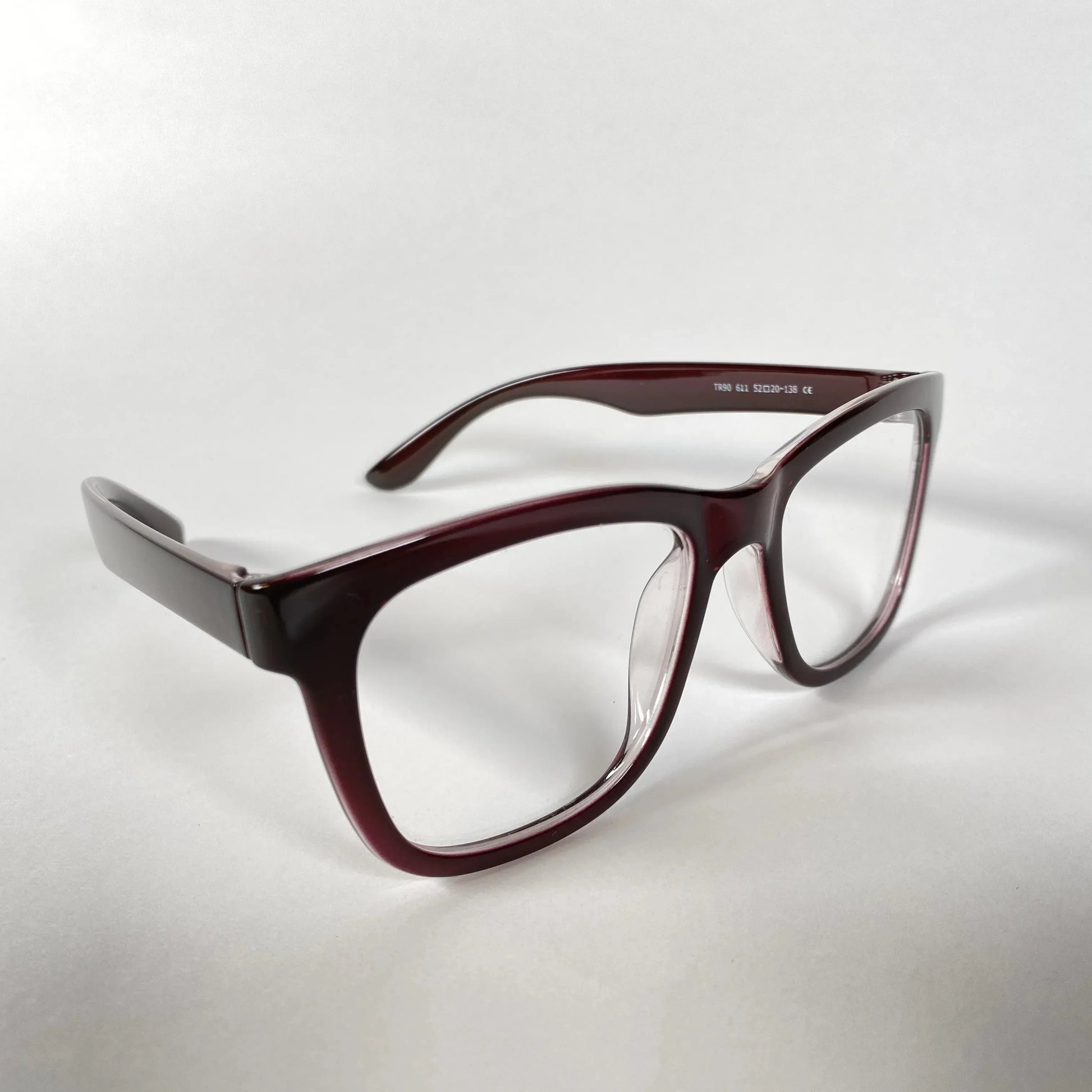 Burgundy horn-rimmed eyeglasses frames on white background