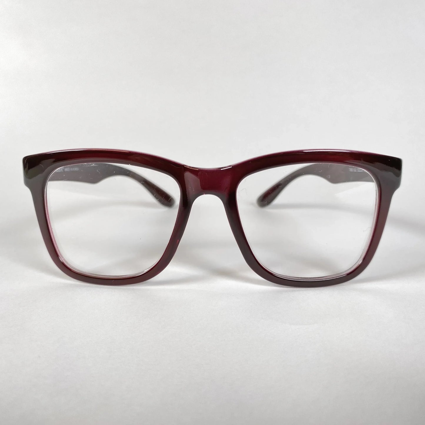 Front view of burgundy horn-rimmed eyeglasses with square lenses on white background