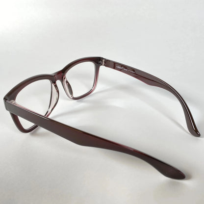Side view of horn-rimmed eyeglasses with burgundy acetate frame on white background