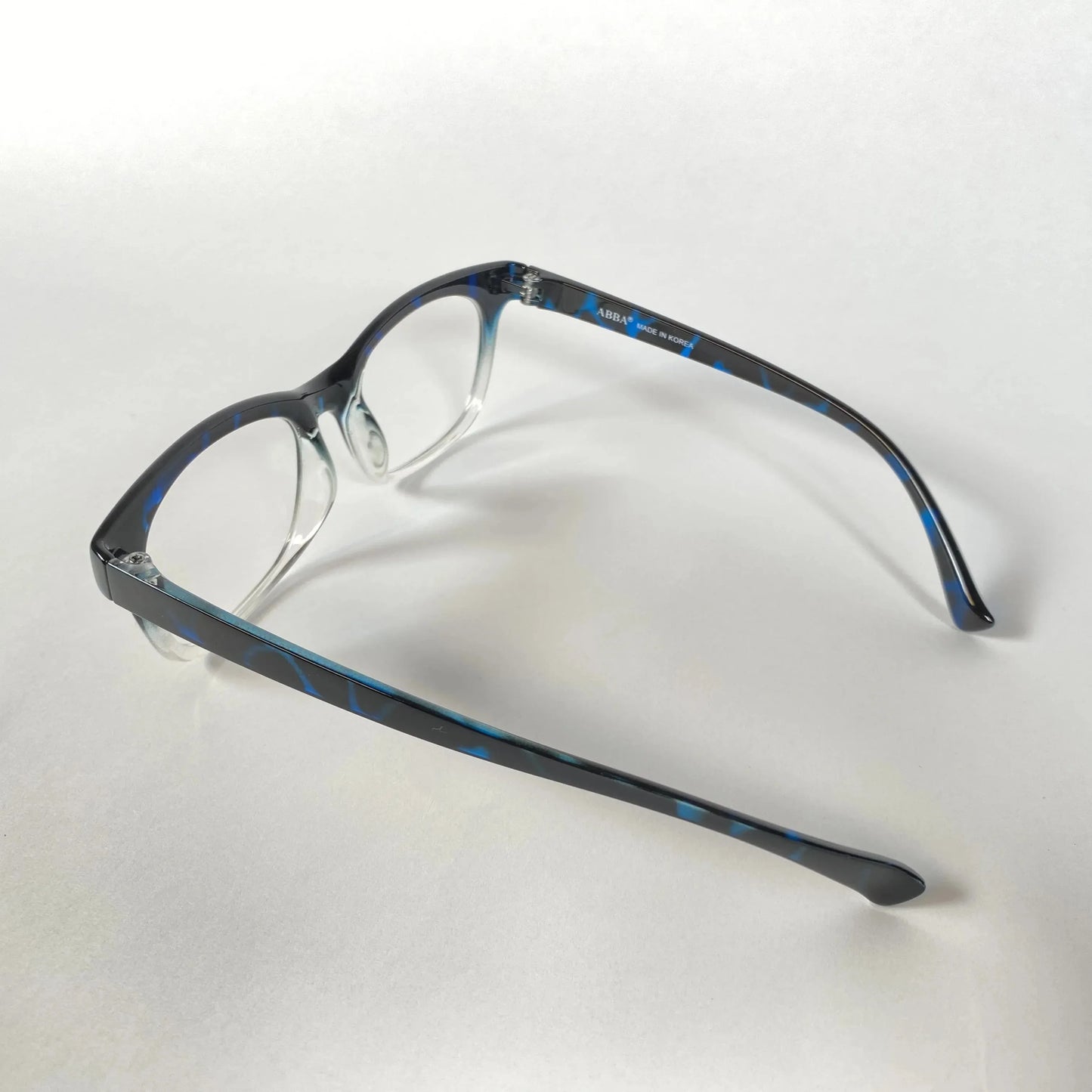 Blue marble-patterned eyeglasses frame side view on white background