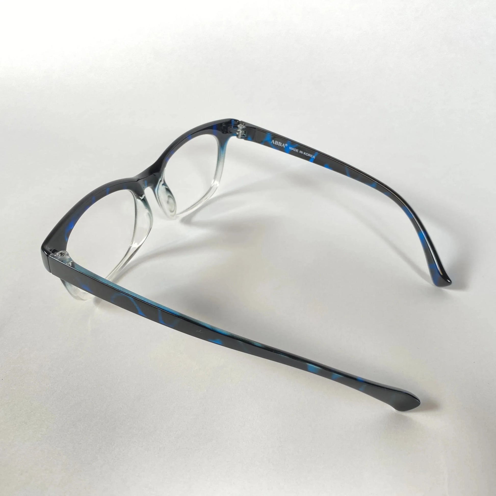 Blue marble-patterned eyeglasses frame side view on white background