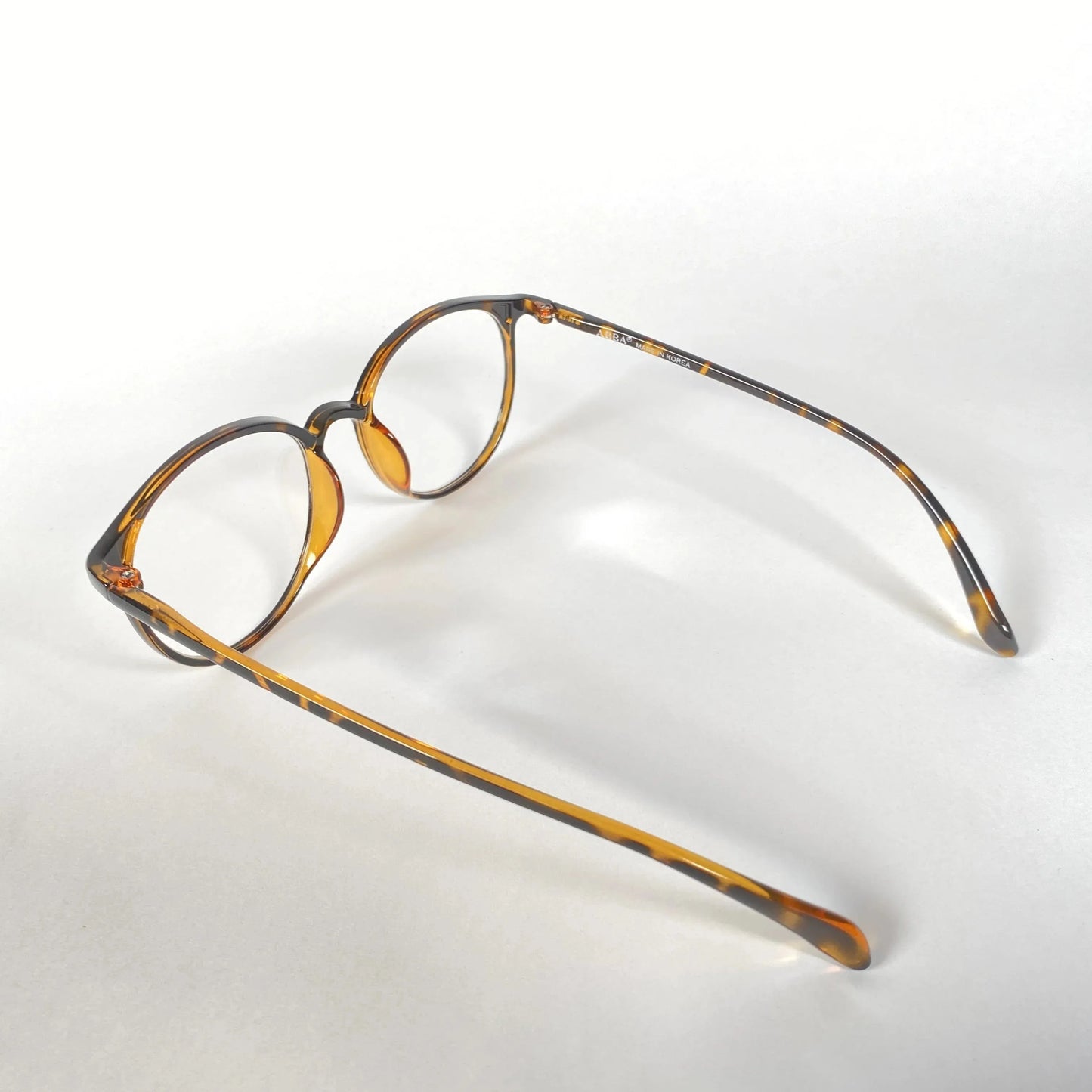 Round tortoiseshell eyeglasses with havana brown pattern on white background