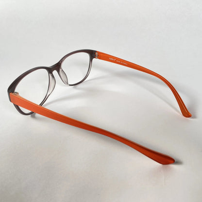 Brown and orange eyeglasses with clear lenses on a white background, side view.