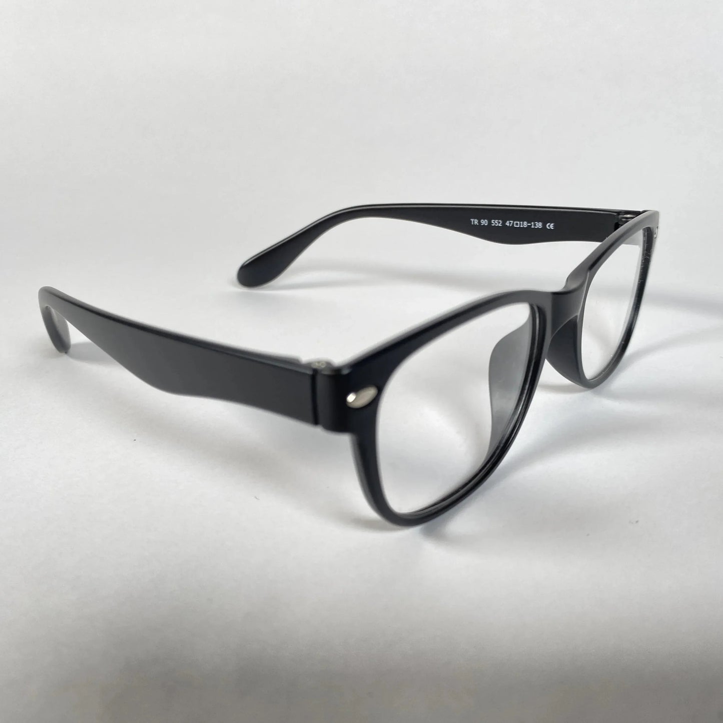 Black kids' eyeglasses with clear lenses on white background, angle view.