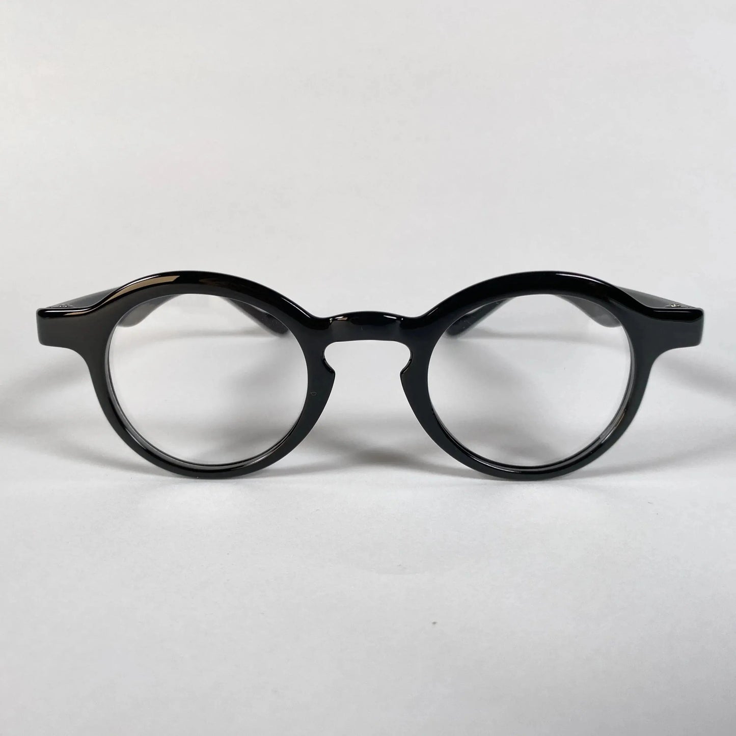 Black round metal eyeglasses with thick frame on white background