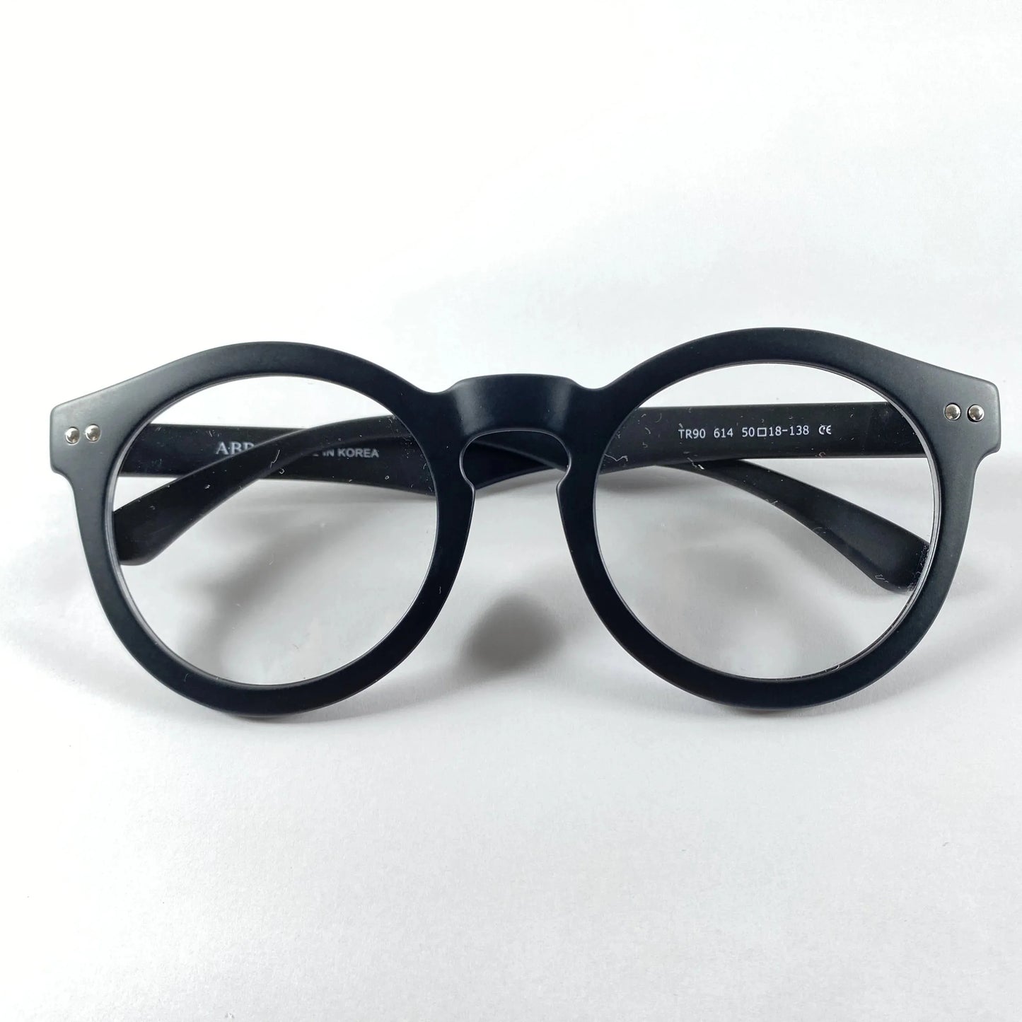 Black round eyeglasses frame with clear lenses on white background
