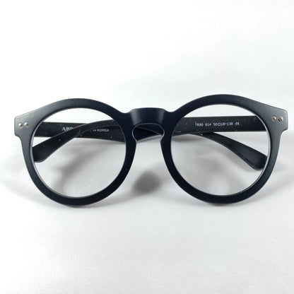 Black round eyeglasses frame with clear lenses on white background