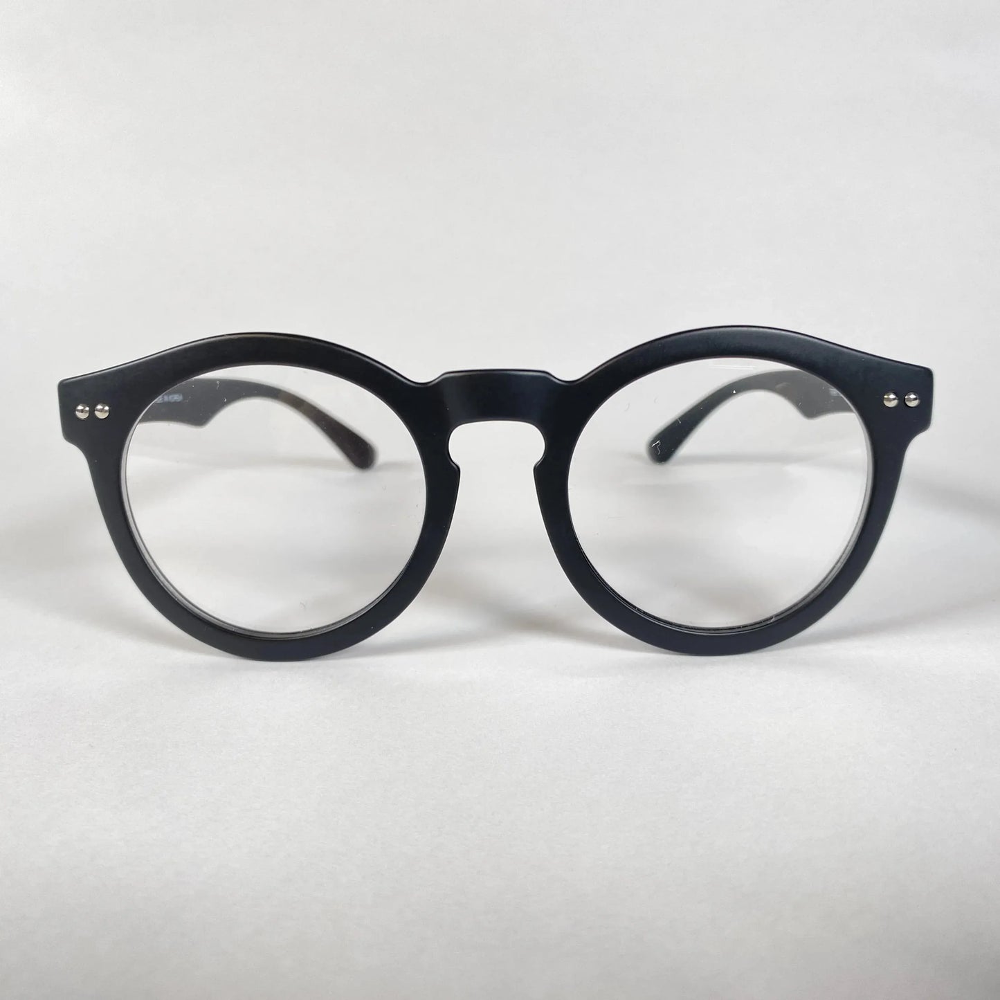 Black round eyeglasses with thick frame on white background, modern eyewear style
