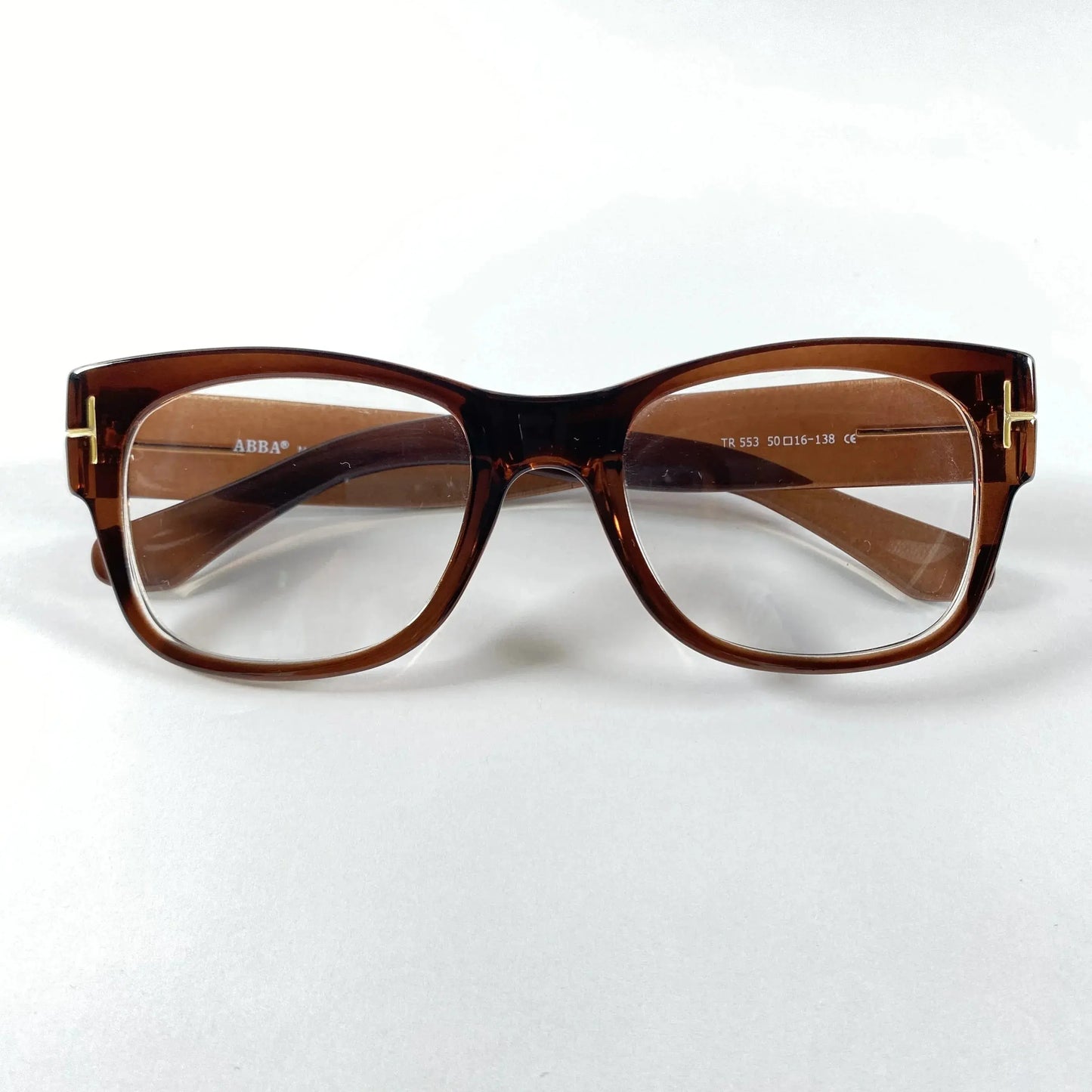 Brown gold detail rectangular eyeglass frame with clear lenses on white background