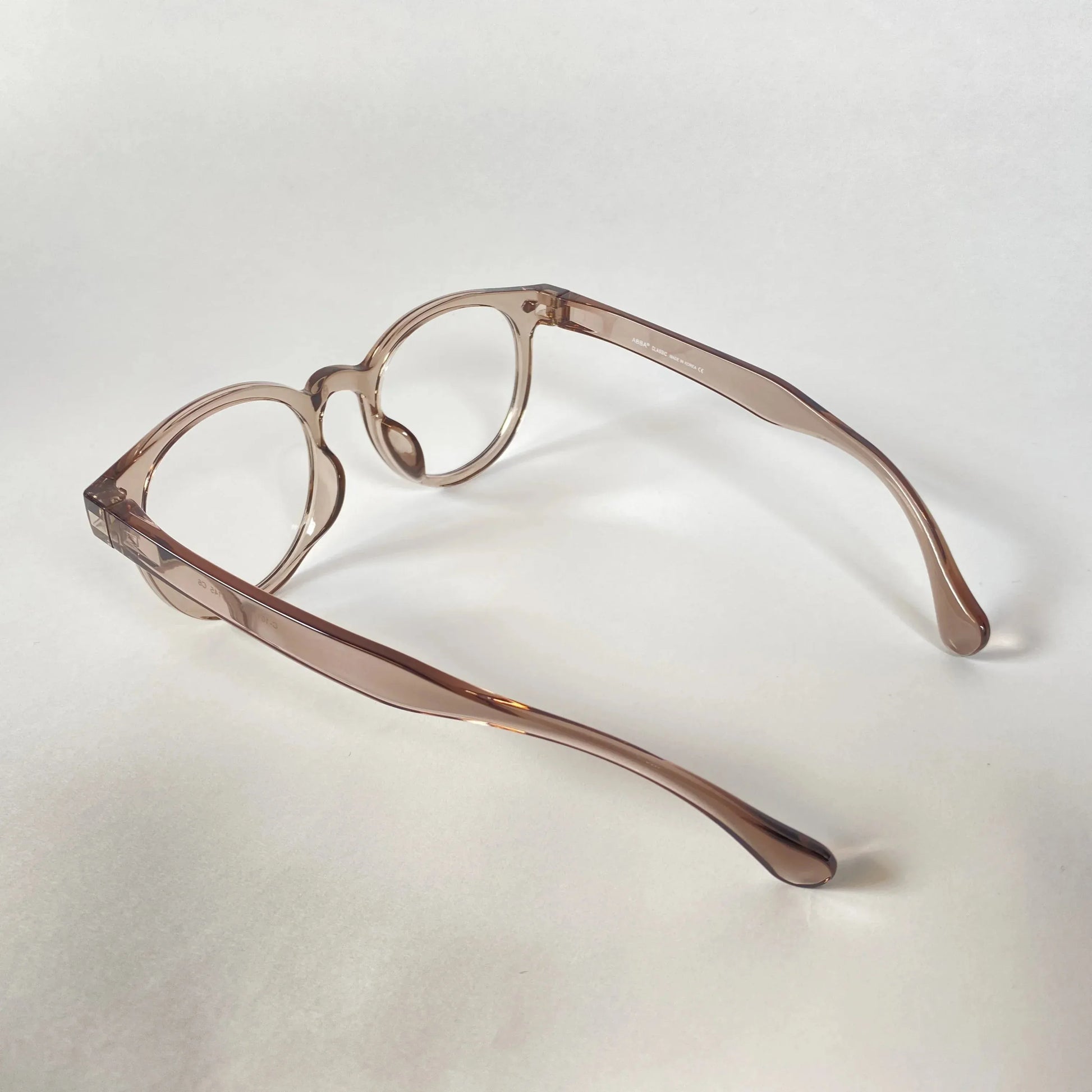 Round grey transparent eyeglasses with thick frames on a white background